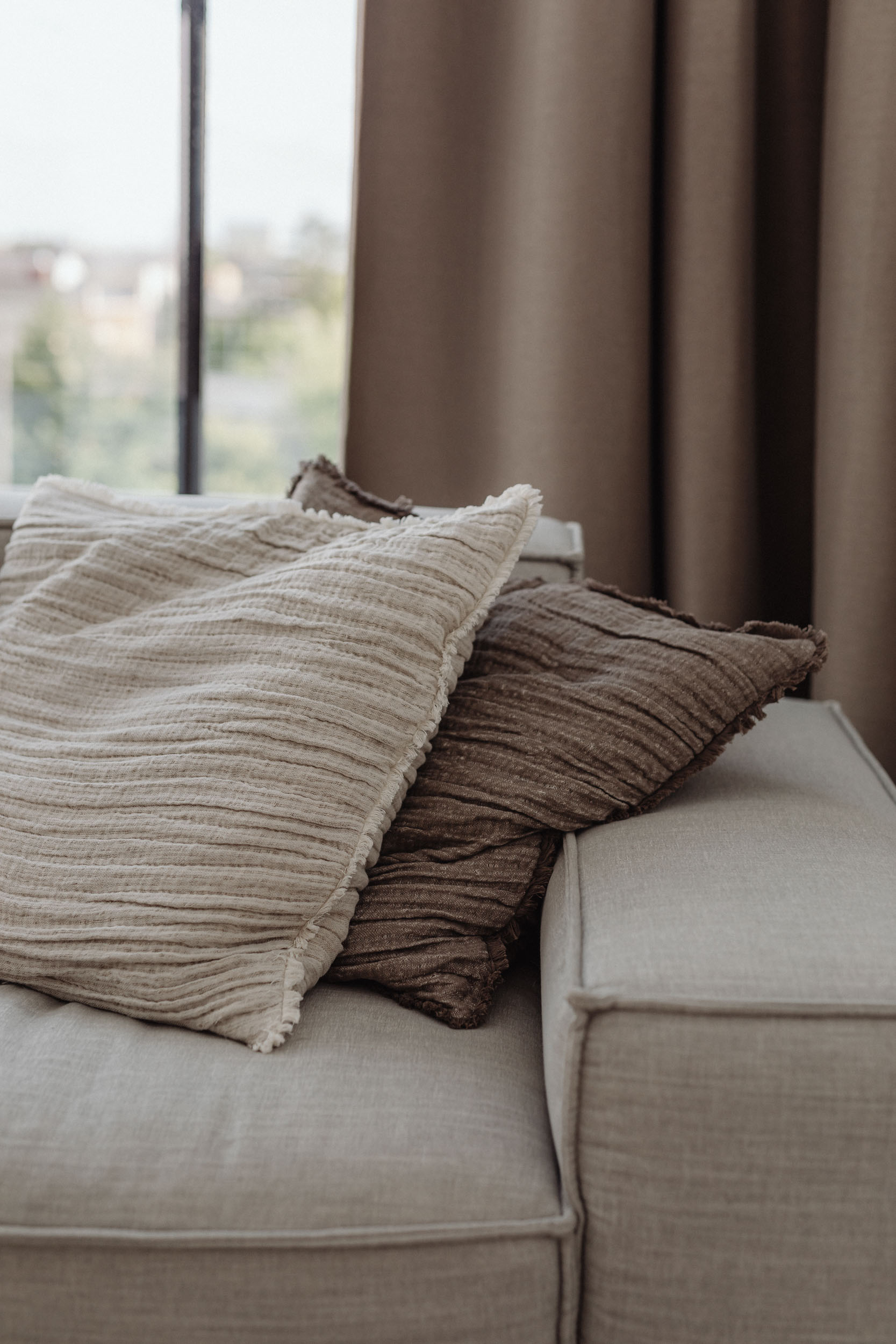 A cozy couch with colorful pillows next to a bright window inviting a warm and relaxed atmosphere 1