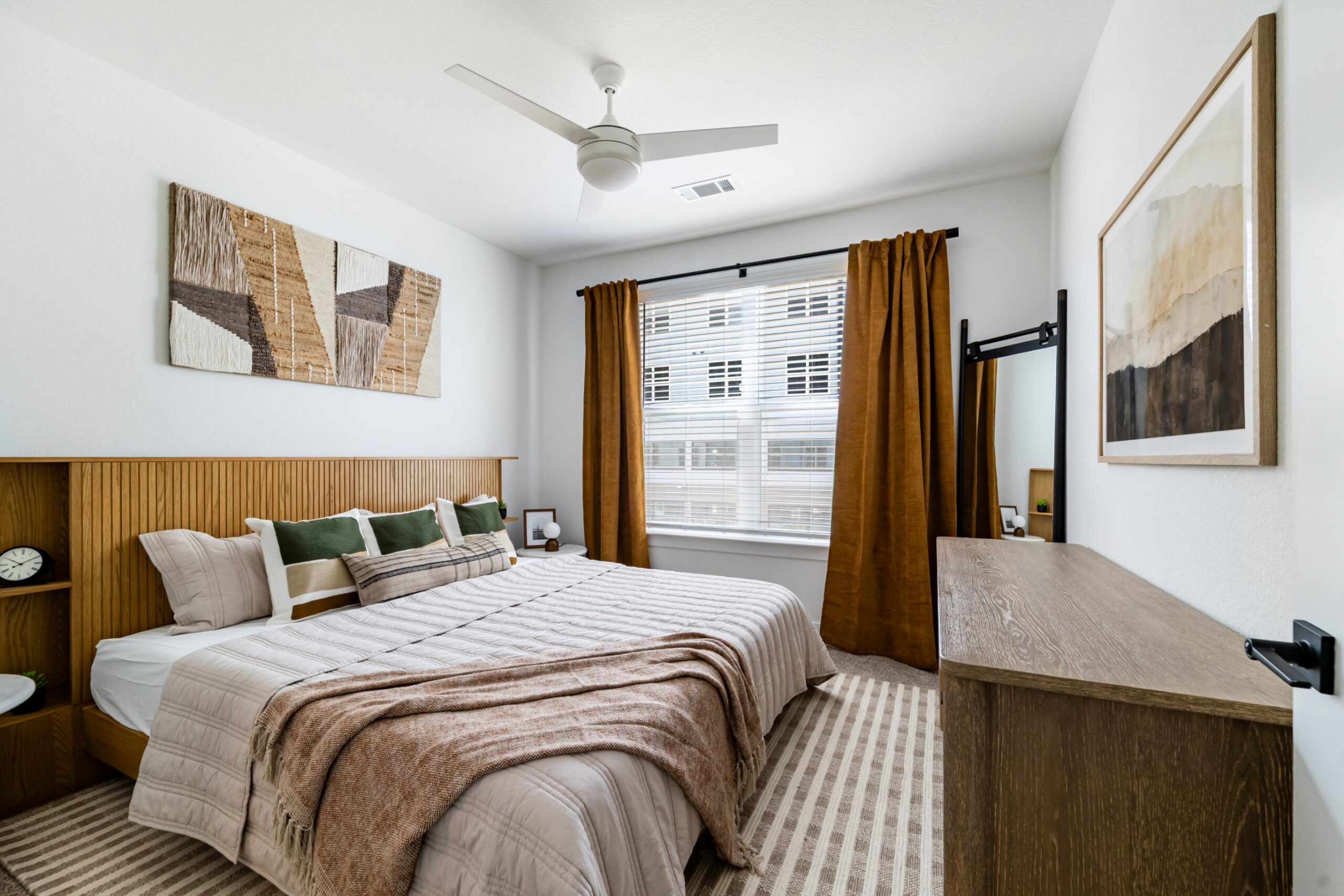 Model bedroom with natural lighting and a ceiling fan at Banyan High Point
